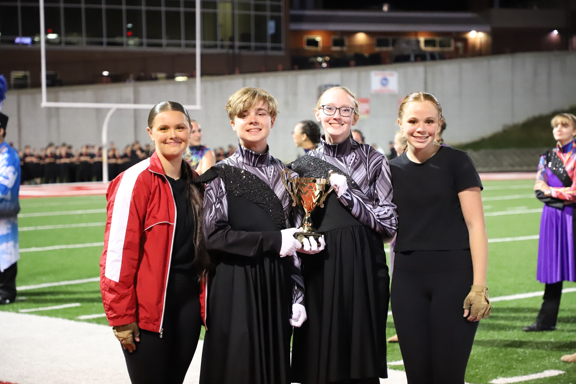 Students celebrating with a Festival of Bands trophy